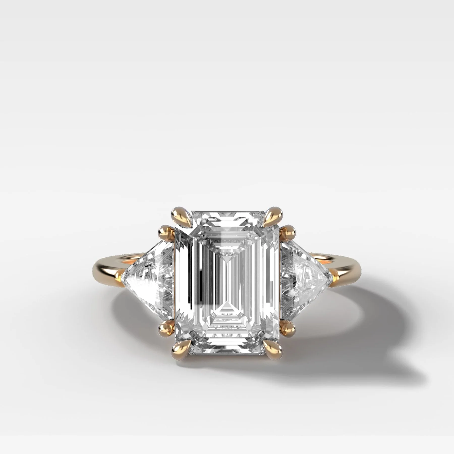 Three Stone Engagement Ring with Shield Side Stones and an Emerald Cut Diamond